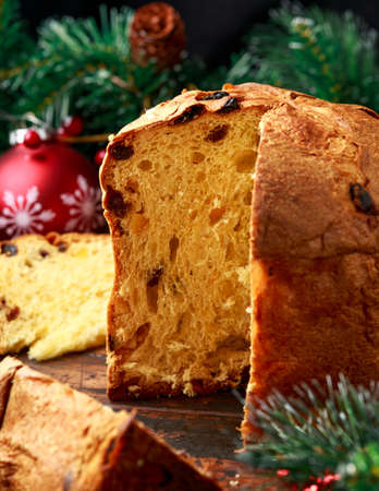 Christmas panettone cake with decoration, gifts, green tree branch on wooden rustic tableの写真素材