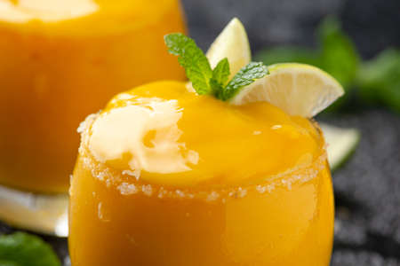 Mango smoothie margarita with lime and mint. Summer cold drink with iceの写真素材