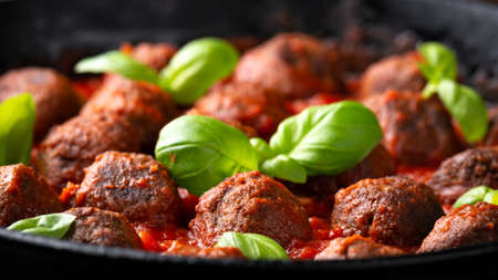 Vegetarian spaghetti with meat free, vegan meatballs in rich tomato sauce in iron cast panの写真素材