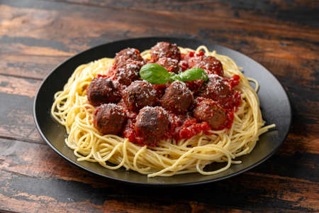 Vegetarian spaghetti with meat free, vegan meatballs in rich tomato sauce, grated cheese and basil leavesの写真素材