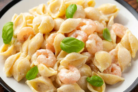 Italian conchiglie prawn, shrimp pasta in a creamy sauce on plate.の写真素材