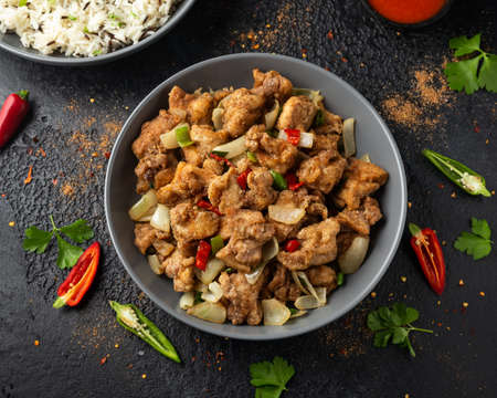 Stir fry chinese salt and pepper chicken with rice in grey bowlの写真素材