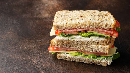 Sandwiches with lettuce, slices of fresh tomatoes, salami and cheese.の写真素材