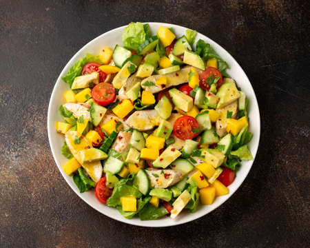 Tasty Chicken mango salad with avocado, cucumber, cherry tomatoes. Healthy foodの写真素材