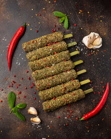 Raw lamb Kofta kebabs on skewers with mix of herbs. Ready to cookの写真素材