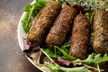 Homemade Kofta kebabs on skewers with vegetables on white plateの写真素材