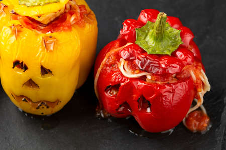 Jack o lanterns stuffed yellow and red pepper for Halloween.