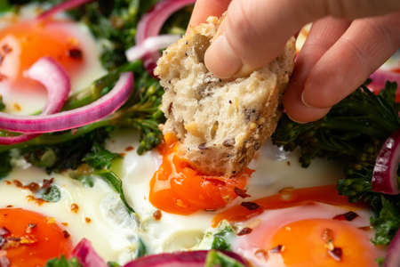 Green shakshuka with golden yolk eggs, kale, spinach and tender broccoli served with pickled onions...