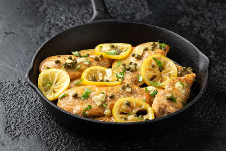 Chicken Piccata with capers, white wine sauce in iron cast pan. Italian foodの写真素材