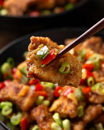 Stir fry salt and pepper pork loin with herbs in black bowl. Asian foodの写真素材