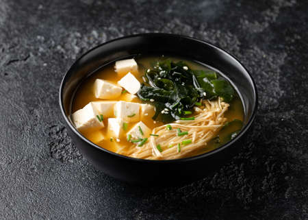 Rich miso soup with enoki mushrooms, wakame seaweed and tofu, vegetarian, vegan Asian food.の写真素材