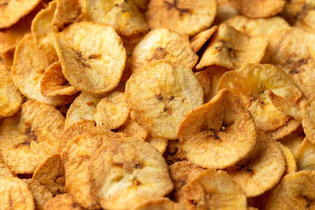 Sweet dried banana chips, snack background, texture