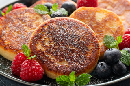 Cottage cheese pancakes served with blueberries, raspberries, strawberry jam and mint leaves,...