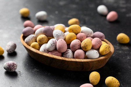 Easter mini eggs, chocolate candy in wooden bowlの写真素材