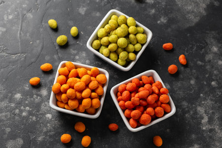 Assortment of crunchy peanuts snack. Green wasabi, Red spicy chilli, yellow jalapeno cheese