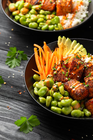 Firecracker salmon poke bowl with edamame, avocado carrot and riceの写真素材