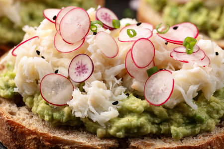 Crab meat and smashed avocado and radishes Sourdough bread toastsの写真素材