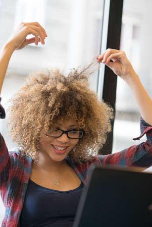 Beautiful girl working on her laptop while drinking coffeeの写真素材