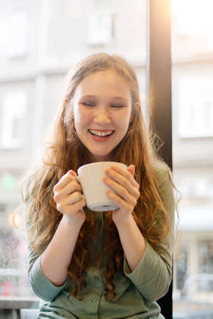 Young girl holding a cup of teaの写真素材