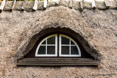 old window in a thatched roofの写真素材