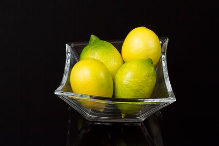 Four lemons in a glass Bowlの写真素材
