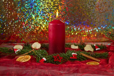 burning red candle with fir branchesの写真素材