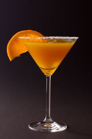 Orange cocktail with orange slice on edgeの写真素材