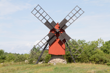 A small windmill stands on a stone pileの写真素材