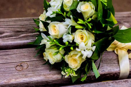 wedding rings lie and beautiful bouquet as bridal accessoriesの写真素材