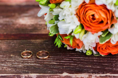 wedding rings lie and beautiful bouquet as bridal accessoriesの写真素材