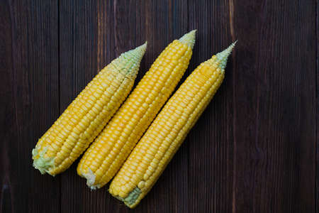 Grains of ripe corn on wooden background.