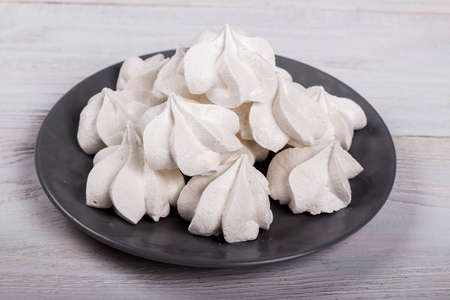 merengues on gray plate on white wooden background, sweet and tastyの写真素材