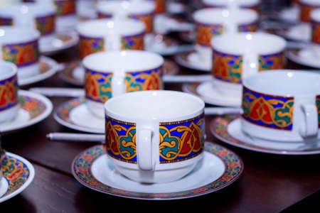 many rows of pure colorful cup and saucer with teaspoon