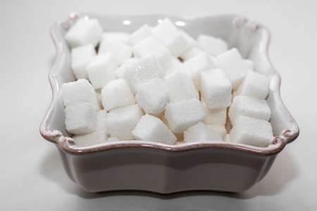 Sugar cubes in a white square bowl, close-upの写真素材