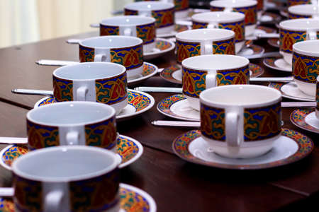 many rows of pure colorful cup and saucer with teaspoon