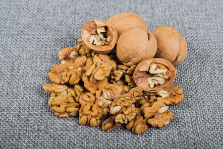 whole walnuts and kernels on burlap background, healthy brain food