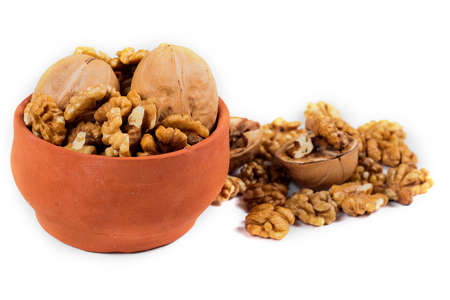 walnut kernels isolated on white background, in ceramic pot, healthy food