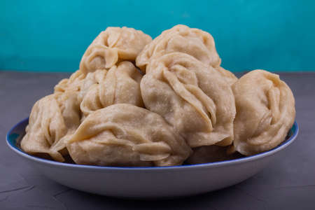 Delicious mantas on a plate on gray background, Asian cuisine, traditional national dish.