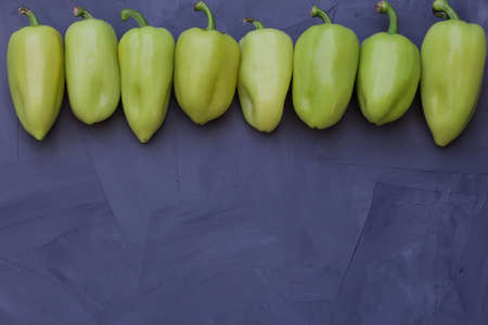 some green bell peppers on gray background, top view