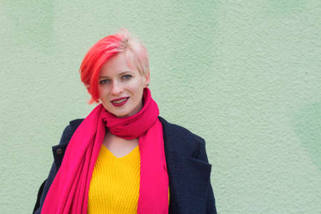 Beautiful young woman with multicolored hair dressed in bright colored clothes and wearing glasses...