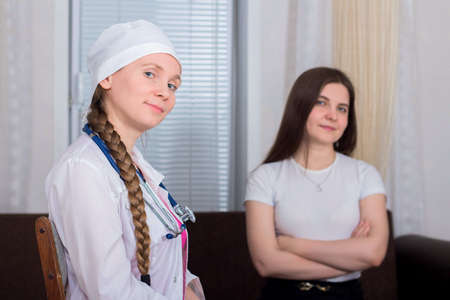 Female patient receives medical advice from female doctor at home, medicine conceptの写真素材