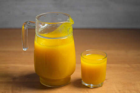 Delicious fresh pumpkin juice in a glass and glass jug