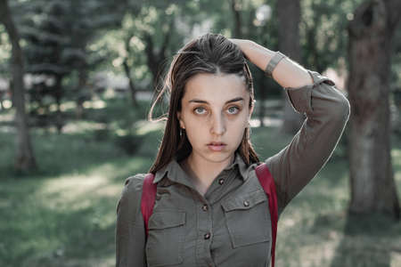Portrait of a beautiful young woman in a summer park. Cinematic photo processing.の写真素材