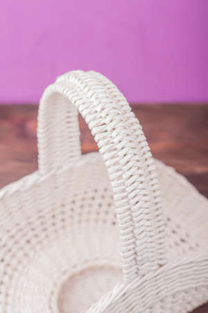 Beautiful white vintage wicker basket on a wooden table. An empty wicker basket made of paper tubesの写真素材