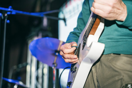 The guitarist on stage is playing an electric guitar. close-up of the guitarist's fingersの写真素材