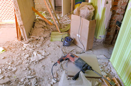 Drill on the dirty and dusty floor in a house under construction, remodeling, renovation, extension, restoration, overhaul and reconstruction.の写真素材