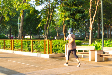 Blur image of people running,walking,jogging in park with bokeh on day time for background usage.の写真素材