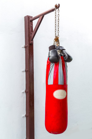 Boxing gloves and Punching bag for boxing or kick boxing sport, isolated on white wall background.の写真素材