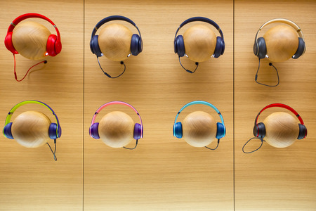 Colourful stylish headphones on wooden background.