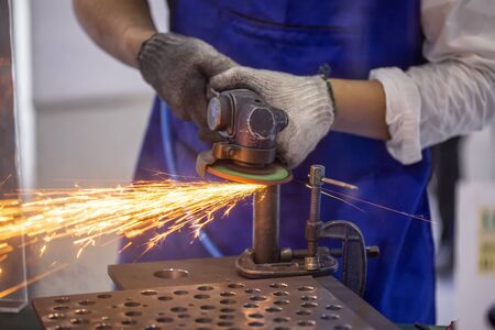 Roofer using a angle grinder to cut a metal.
